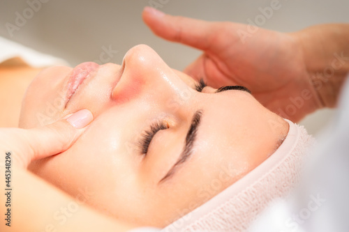 Beautician making lymphatic drainage face massage or facelifting massage at the beauty salon
