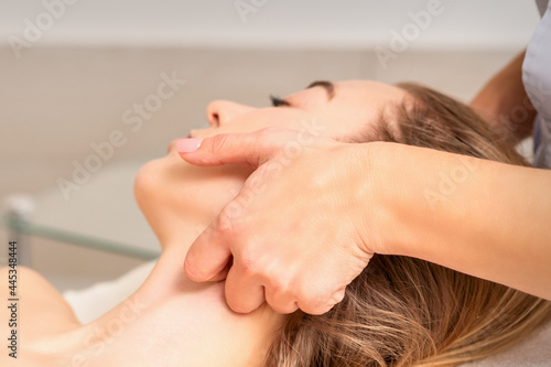 Beautician making lymphatic drainage face massage or facelifting massage at the beauty salon