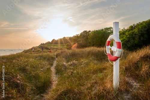 Schilderij op canvas Rettungsring an der dänischen Küste bei Sonnenuntergang auf der Insel Bornholm