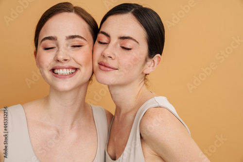 Young two women in undershirt posing and smiling at camera