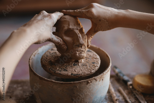 Young woman sculptor artist creating a bust sculpture