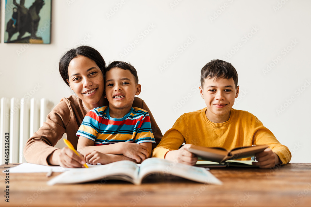 Two boys doing homework with their mother at home Two boys doing homework with their mother at home