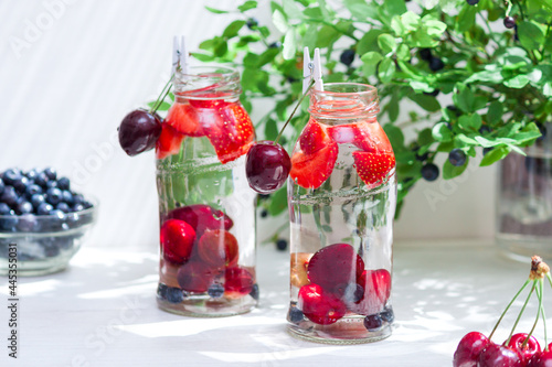 Variety of fruit with detox water in glass small bottles. Refreshing summer drinks. Healthy diet concept.