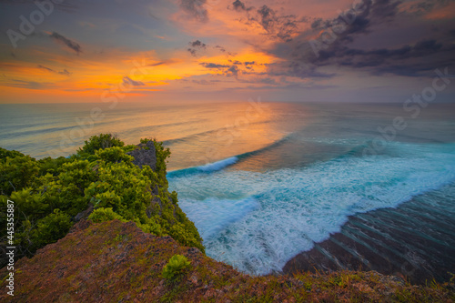 Seascape. Spectacular view from Uluwatu cliff in Bali. Sunset time. Blue hour. Ocean with motion foam waves. Waterscape for background. Nature concept. Soft focus. Slow shutter speed.