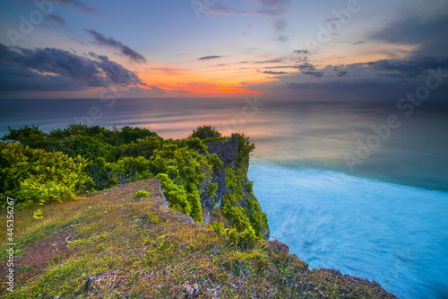 Seascape. Spectacular view from Uluwatu cliff in Bali. Sunset time. Blue hour. Ocean with motion foam waves. Waterscape for background. Nature concept. Soft focus. Slow shutter speed.