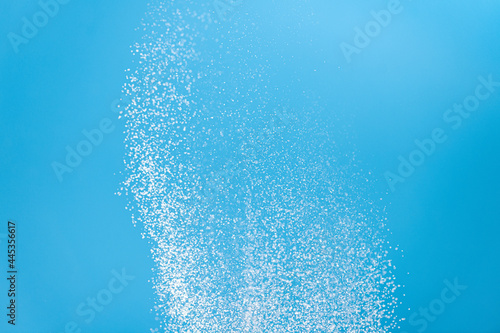 Fototapeta Naklejka Na Ścianę i Meble -  White powder explosion. White powder splash isolated on blue background. Flour sifting on a blue background. Explosive powder white