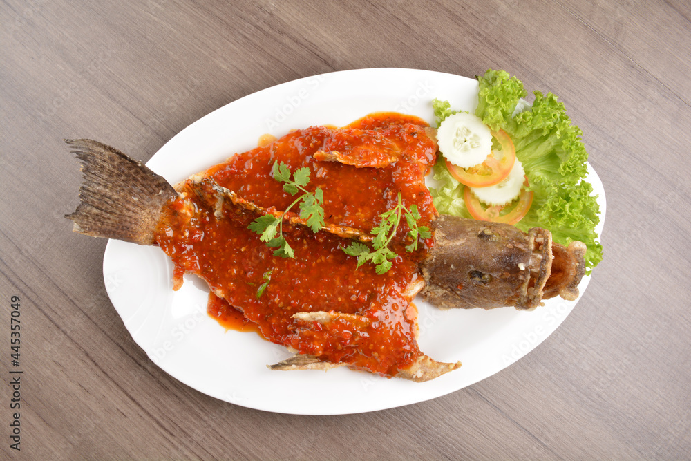 deep fried crispy whole grouper fish with spicy sambal chilli sauce on wood background asian halal menu deep fried crispy whole grouper fish with spicy sambal chilli sauce on wood background asian halal menu