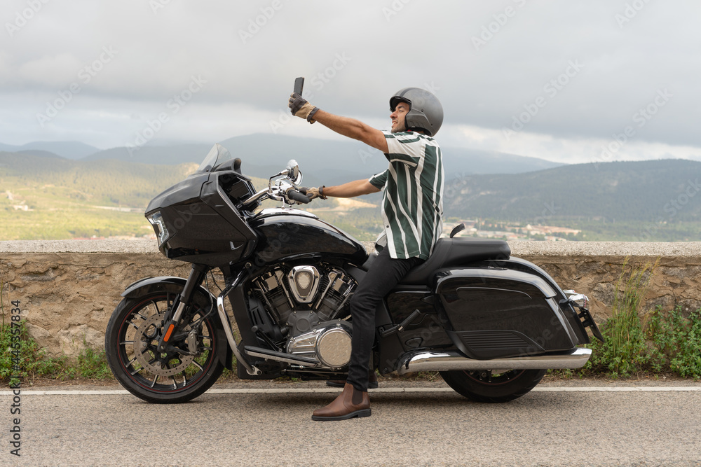 Obraz premium Chico haciendo una foto sentado en la moto.
