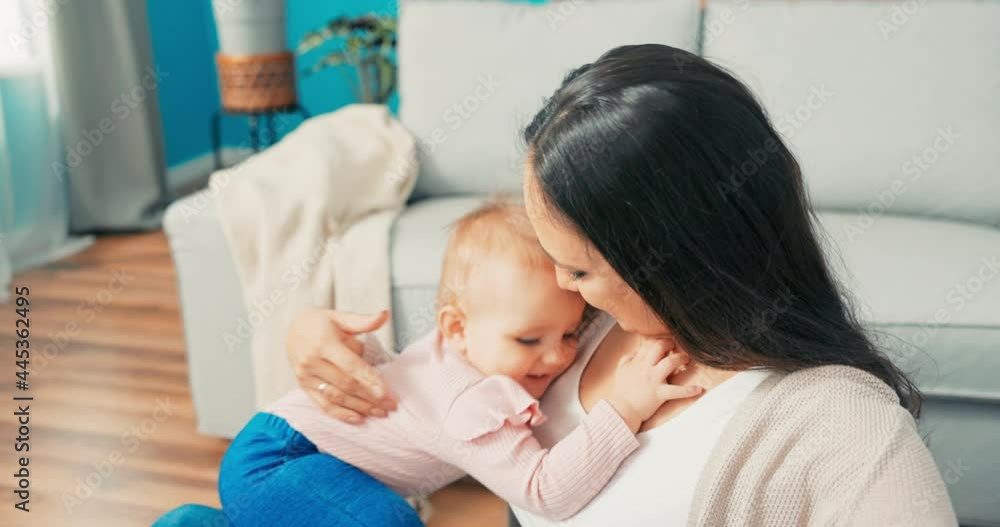 Beautiful woman with long hair, influencer, blogger records video, vlog with sweet little daughter dressed in pink bodysuit, smiles, little girl hides ashamedly in mom's arms, hugs Beautiful woman with long hair, influencer, blogger records video, vlog with sweet little daughter dressed in pink bodysuit, smiles, little girl hides ashamedly in mom's arms, hugs