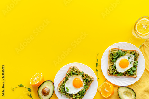 Fototapeta Naklejka Na Ścianę i Meble -  Eggs and avocado with spinach on toasted bread. Top view