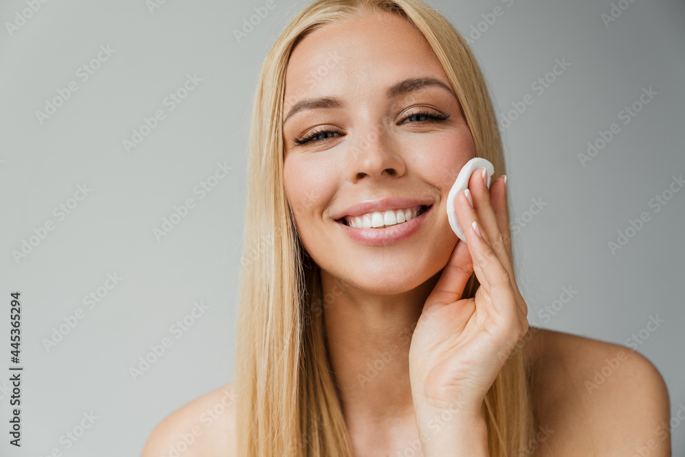 Half-naked blonde woman laughing while using cotton pad Half-naked blonde woman laughing while using cotton pad