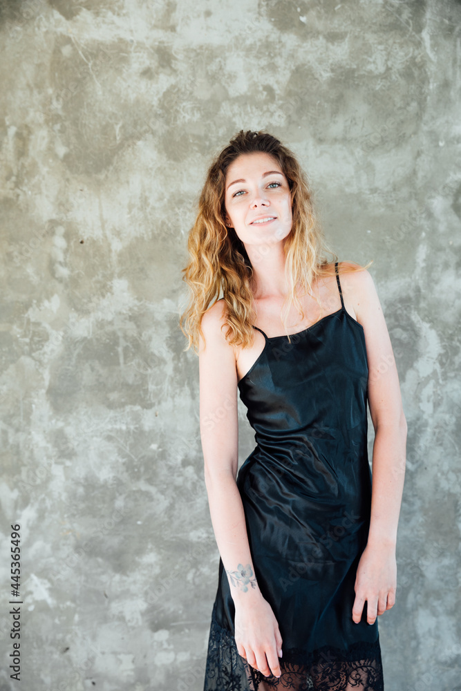 portrait of a beautiful woman in a black dress on a gray background