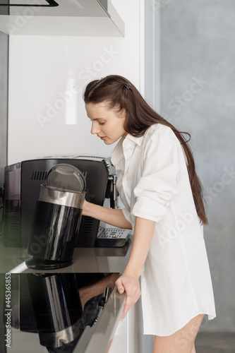 Young woman looking inside of electrical kettle