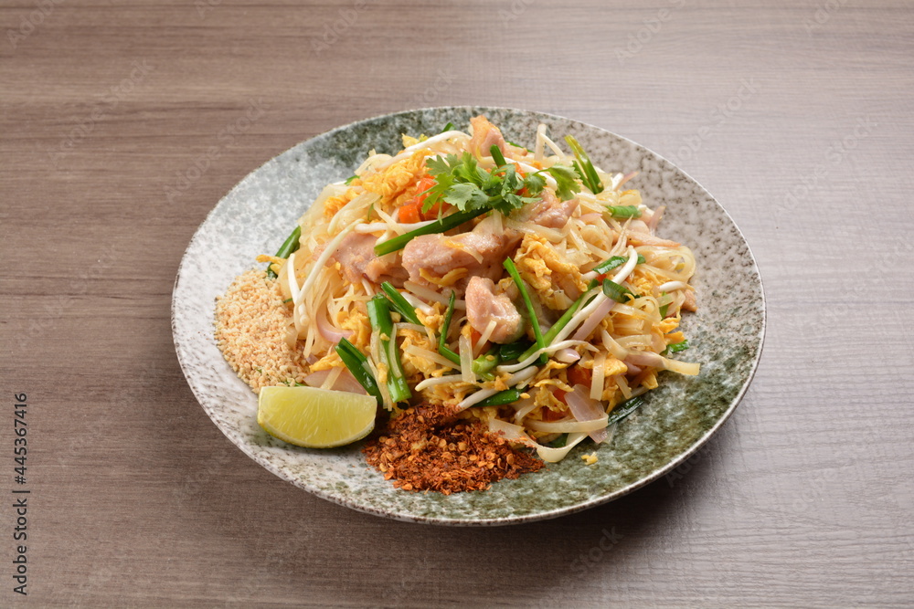 wok fried noodle phad Thai with chicken meat on wood background asian halal set lunch menu