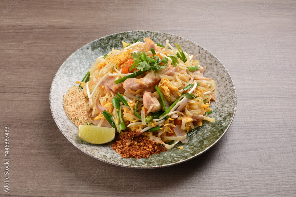 wok fried noodle phad Thai with chicken meat on wood background asian halal set lunch menu wok fried noodle phad Thai with chicken meat on wood background asian halal set lunch menu
