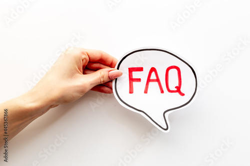 Hands with faq word on paper bubble. Frequently asked questions concept