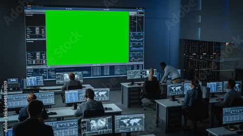 Obraz na płótnie Big Green Screen Horizontal Mock Up in a Mission Control Center Room with Flight Director and Other Controllers Working on Computers