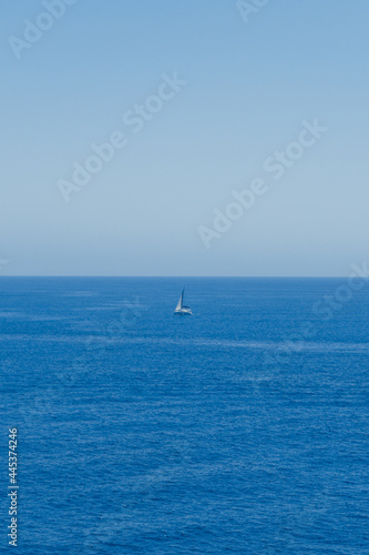 Mar azul en verano con un barco velero en medio de la imagen. © Jeremias Rodriguez