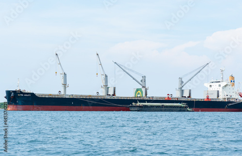 Crane in the industrial ship in the ocean blue water and blue sky landscape,Logistic and transportation ship concept in the sea