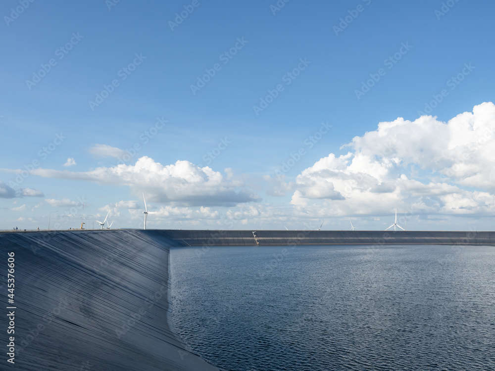 Reservoir on the mountain landscape with wind turbine and cloudy on blue sky,Water in reservoir