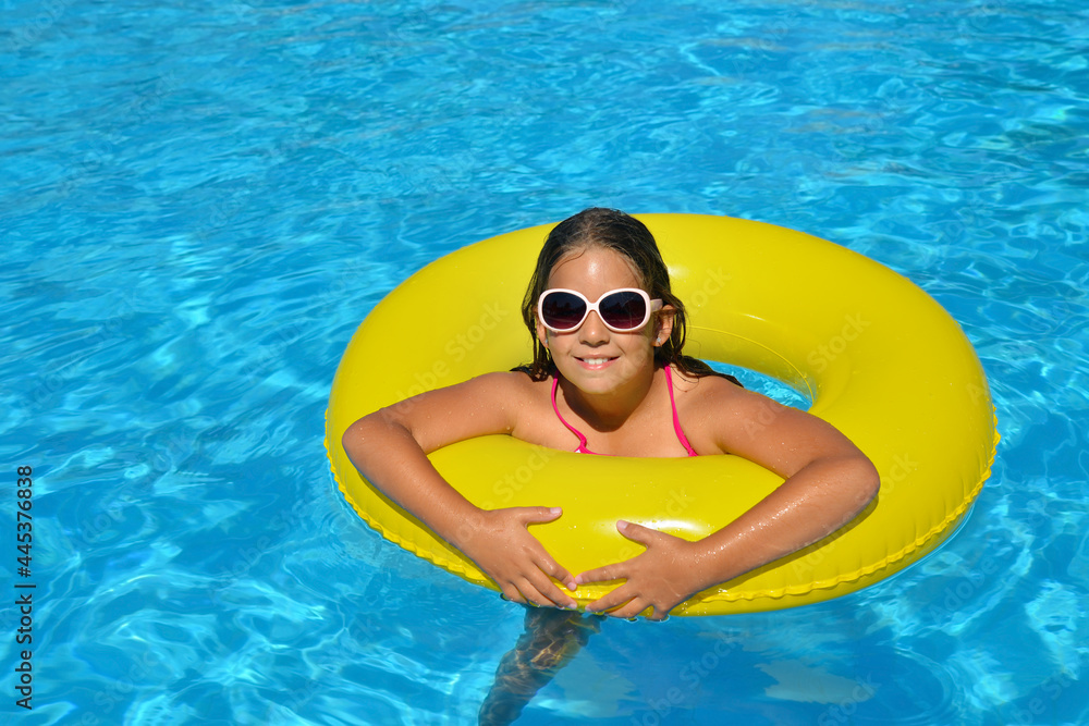 Real adorable girl relaxing in swimming pool
