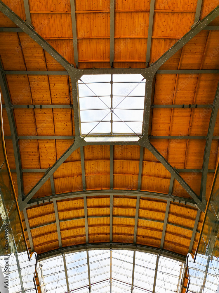 Obraz premium Looking up to wooden roof with windows of railway station