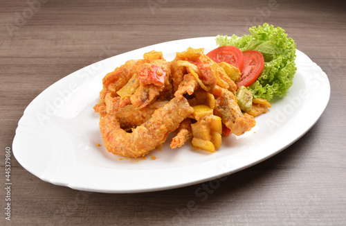 wok fried tiger prawn in salted egg yolk curry paste sauce on wood table asian halal menu