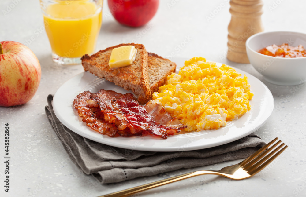 traditional scrambled egg breakfast with bacon and toast