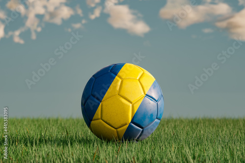 Soccer ball with the national colors of Sweden on a green meadow. Leather in slightly used look. Background blue with clouds. 3D illustration.