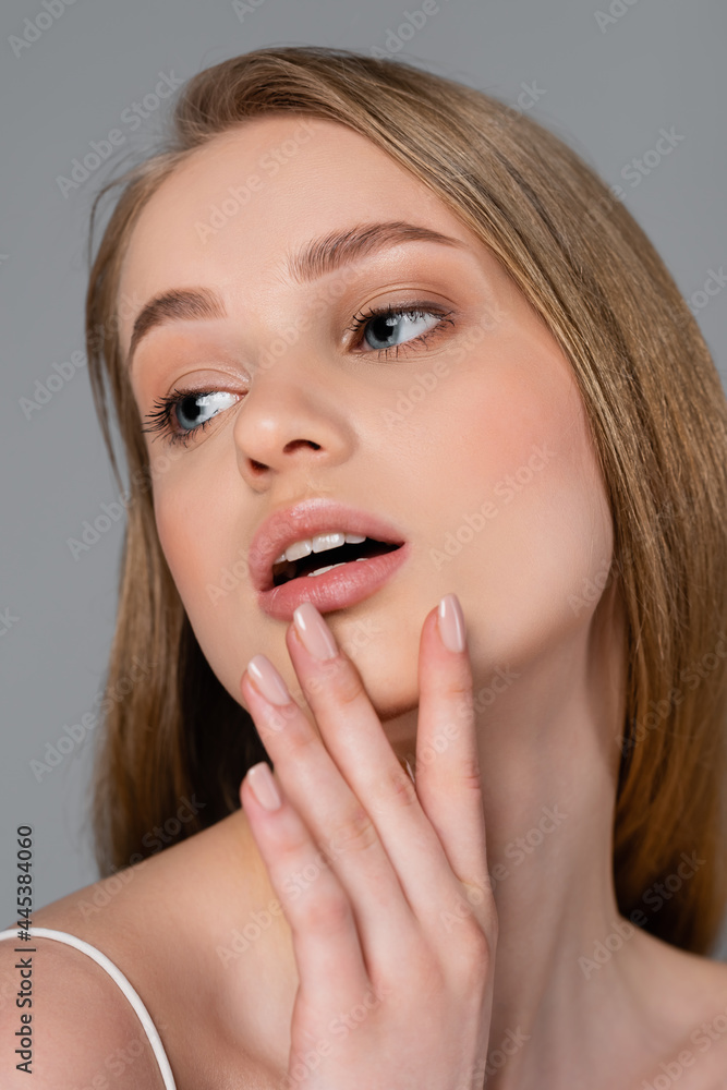 pretty young woman with makeup touching perfect skin isolated on gray pretty young woman with makeup touching perfect skin isolated on gray