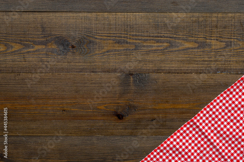 Red picnic cloth on wooden table, top view