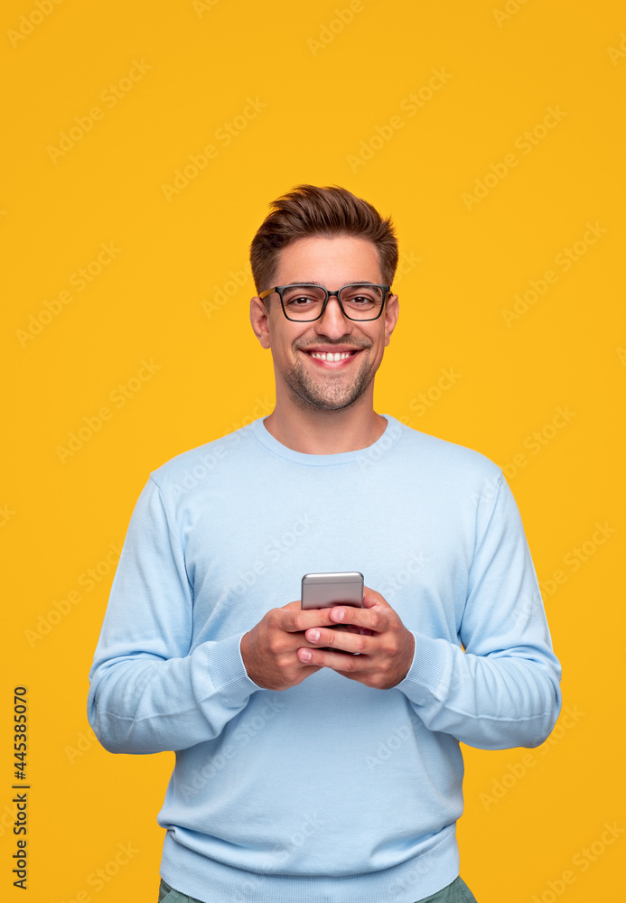 Young man using smartphone and smiling Young man using smartphone and smiling