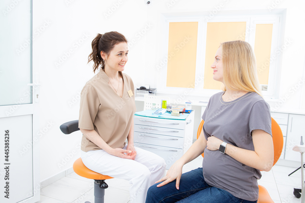 Fototapeta premium positive pregnant woman in dentist office, consultation with young woman dentist. dental treatment for pregnant women