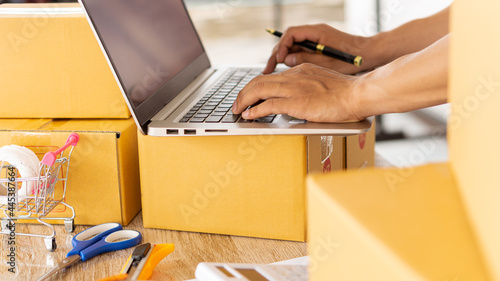Start an SME business, online shopping working on laptop computer with parcel box at home - online SME business and delivery concept during coronavirus outbreak.