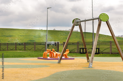 fragment of a modern playground with a swing. Selective focus