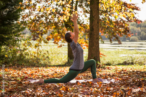Yoga being practiced in the fall surround by autumn leaves