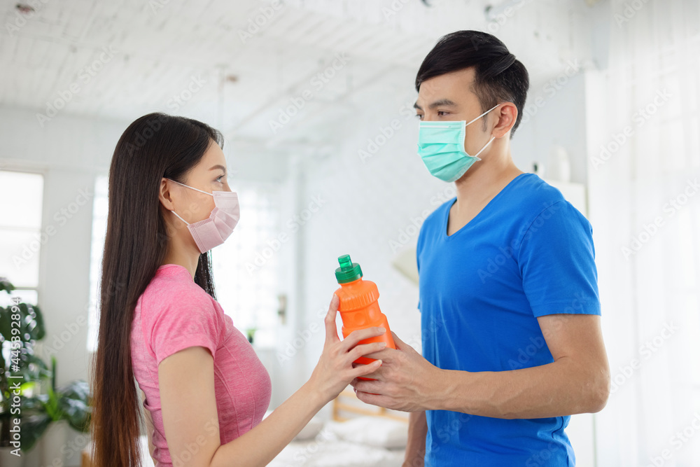 Young couple wear with medical mask workout together and holding water bottle. Young couple wear with medical mask workout together and holding water bottle.