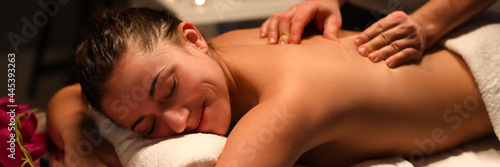 Uśmiechnięta masażystka robi masaż pleców w centrum spa
