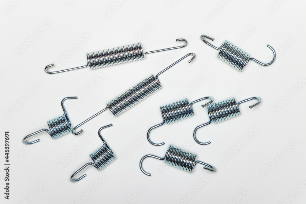 Repair kit for brakes, many metal springs of various lengths. Set of spare parts for car brake repair. Details on white background, copy space available. UHD 4K.