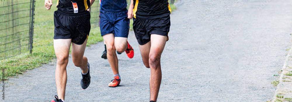 Boys running 5K race on gravel path at park Boys running 5K race on gravel path at park
