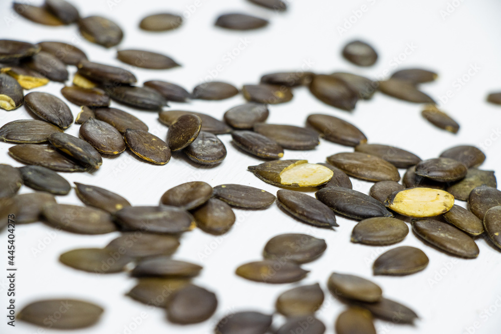 Natural pumpkin seeds lying on a white wooden background Natural pumpkin seeds lying on a white wooden background