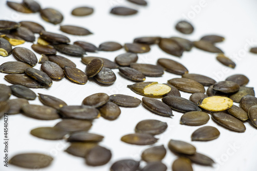 Natural pumpkin seeds lying on a white wooden background