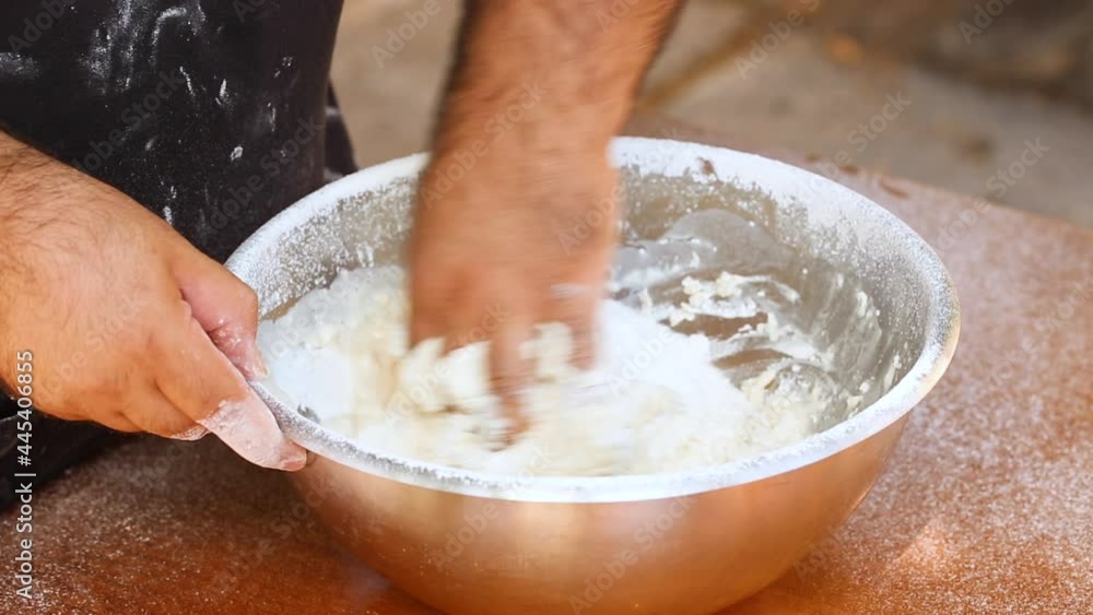 Man kneading dough with his hands in a bowl, outdoor Man kneading dough with his hands in a bowl, outdoor