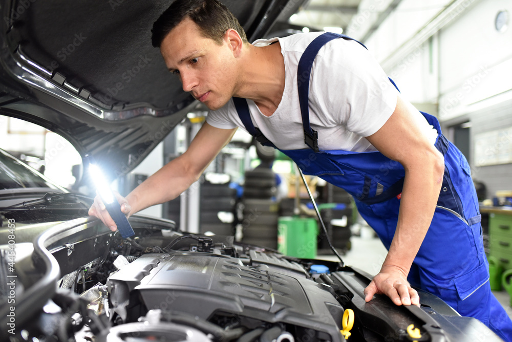 car mechanic in a workshop repairing a vehicle car mechanic in a workshop repairing a vehicle