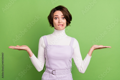 Photo of young girl bite lips hold hands solution decision choice option advertise isolated over green color background