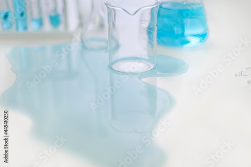 Spilled liquid and glassware on table in laboratory photo
