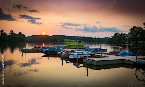 Paddle boats and kayaks docked at Jacobson Park Lake marina in Lexington, Kentucky during sunrise early morning hours