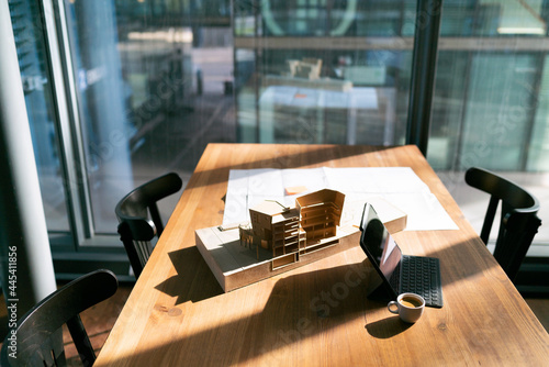 Sunlight falling on blueprint and architectural model at office photo