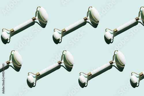 Pattern of marble jade rollers flat laid against mint green background photo