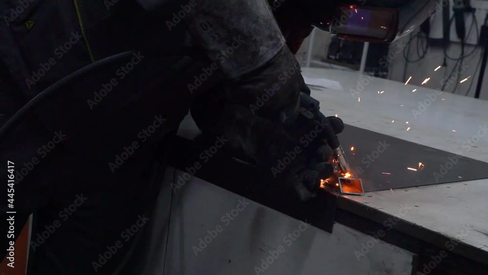 Welder at work in metal industry.Welder is welding assembly parts in factory with protection mask. Welder at work in metal industry.Welder is welding assembly parts in factory with protection mask.
